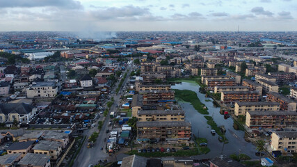 Expansive aerial view of Lagos, Nigeria showcases dense urban landscape under a cloudy sky.