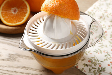 Making juice. Juicer and fresh oranges on wooden table, closeup