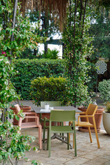 A Cozy Outdoor Seating Arrangement Amidst Lush Greenery and Vibrant Plants Perfect for Relaxation or Enjoying a Cup of Coffee in a Serene Garden Setup