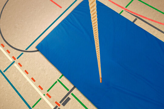 Sporthalle mit Kletterseil und einer Bodenmatte