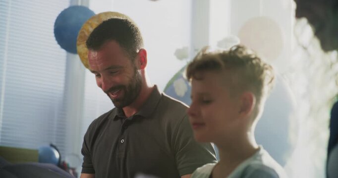 Mother and Father Looking at School Test Results of Their Son During Parents Evening. Parents Happy About Excellent Academic Performance and Behavior of Elementary School Boy. Slow Motion. Close Up.