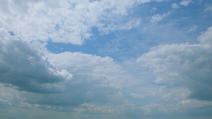 A beautiful scenic view of the sky, with fluffy clouds set against a bright blue background