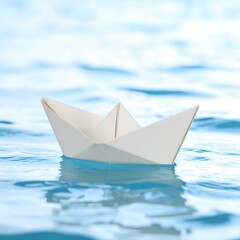 Obraz premium White paper boat floating on calm blue water, symbolizing journey, hope, and new beginnings.