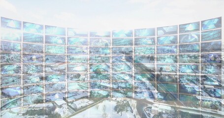 Displaying curved monitor wall projecting binary code and globes in control room over snowy suburb