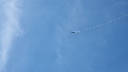 Fighter jet flying in blue sky with contrails
