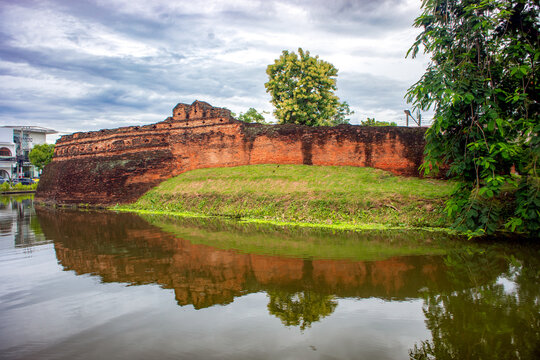 Katam Corner ancient brick wall in Chiang Mai city, Thailand, on the edge of a canal