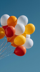 Colorful balloons against clear blue sky create festive atmosphere
