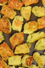A detailed macro shot shows a close-up of a batch of golden-brown fried zucchini gnocchi with a textured crust in a pan