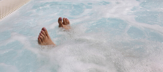 feet of the young woman during the hydrotherapy session in the hot tub