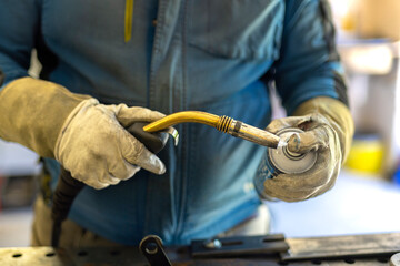 Preparing the welder for welding. Cleaning the welding torch with a protective spray before work