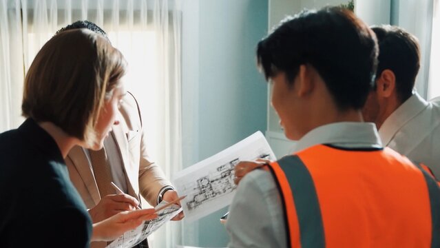 Top view of professional architect engineer team inspect house model while manager holding blueprint and asking about building construction. Group of diverse engineer working together. Alimentation.