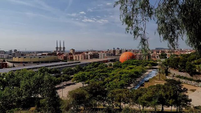 Badalona, Spain-23 August 2024. Panoramic view of the energy towers in Badalona, Spain, from a nature park. The harmony between nature and industry captured from a park overlooking three chimneys.