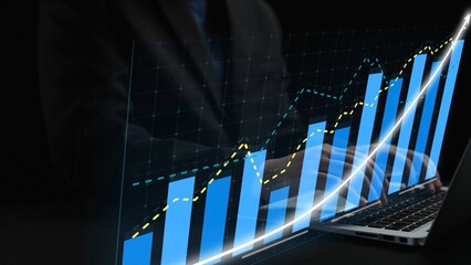 A business professional reviews growth data on a laptop screen, featuring dynamic graphs and charts. The dark background emphasizes the analytical process. Copula