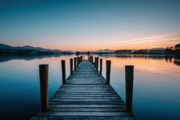 Fototapeta premium Calm wooden pier on serene lake at dawn