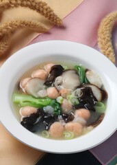 Clear soup featuring shrimp balls, wood ear mushrooms, and king oyster mushrooms in a savory broth. A dish by Hanshunseop.