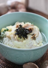 Warm rice served with soft egg, pine mushrooms, onions, and seaweed in light soup. A comfort dish by Master Chef Hanshunseop. Photographed in Korea.