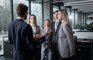 A group of people are standing in a room, smiling and laughing