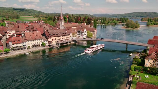 Stein am Rhein Switzerland aerial view of cruise boat passing under bridge slow motion 4k footage Rhine river historic old town Schaffhausen travel destination