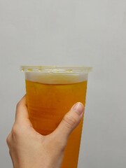 Hand holding a cup of Iced tea. Flowing tea. Chrysanthemum tea 