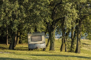 old caravan under pines at sunset on a camping in the French Dr&ocirc;me region
