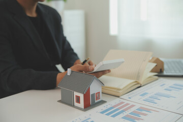 Businessmen holding pens, signing home titles with insurance, care about real estate services and the idea of real estate agents offering interest in installments to their customers.