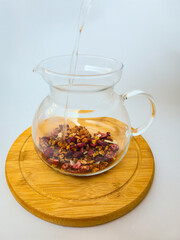 Fruit tea is poured from a teapot into a transparent cup autumn. autumn mood. coziness