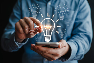 Creative Innovation and Business Solutions Mans Hand Touching Digital Light Bulb Icons on Smartphone Screen for Smart Ideas