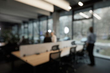 A blurry image of a group of people sitting at a table with laptops