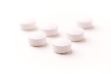 Creatine tablets on paper background. Soft focus. Close up. Copy space.