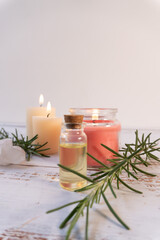 Rosemary branches, quartz oils, and candles on a wooden table