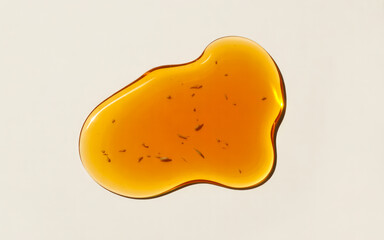 Amber liquid droplet with small particles on white