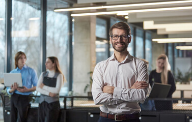 Fototapeta premium A man stands in front of a group of people in a business setting