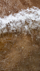 A powerful vertical shot capturing the motion of a cresting wave in the ocean, with a dramatic spray of white foam. This cinematic image is perfect for a social media reel or story