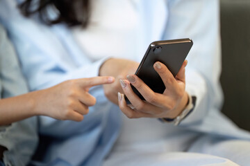 Mother and son exploring smartphone together, enhancing digital literacy.