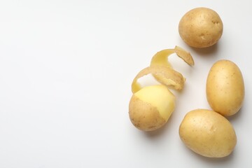 Fresh raw potatoes on light grey background, top view. Space for text