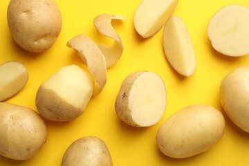 Fresh raw potatoes on yellow background, above view