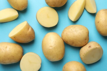 Fresh raw potatoes on light blue background, above view