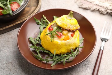 Tasty stuffed pattypan squash with arugula served on grey table, closeup