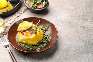 Tasty stuffed pattypan squash with arugula served on grey table. Space for text