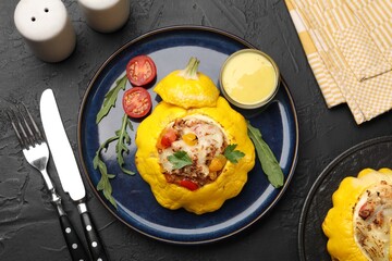 Tasty stuffed pattypan squash served on black table, flat lay