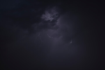 Dark, dramatic storm clouds gather on the horizon, hinting at an approaching thunderstorm. The sky is a canvas of intense grays and deep blues, with a powerful sense of impending weather.