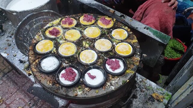Cooking street food in Vietnam. Woman cooks food in frying pan. National Vietnamese cuisine