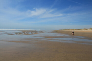 A cyclist rests during a tour along a wild beach.