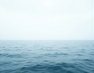 Obraz premium Serene ocean scene with vast blue waters, horizon line visible, calm surface rippling with waves. Softly reflected light, peaceful atmosphere, blue sky with scattered clouds.