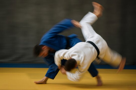 Two judo fighters practicing a dynamic throw on a tatami mat, demonstrating skill and precision in martial arts
