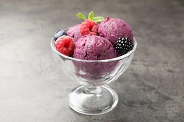 Delicious sorbet with fresh berries and mint in dessert bowl on grey textured table, closeup