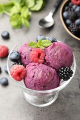 Delicious sorbet with fresh berries and mint in dessert bowl on grey textured table, closeup