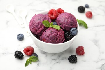 Delicious sorbet with fresh berries and mint in bowl on white marble table, closeup
