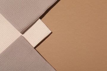 Folded waffle towels on light brown background, flat lay. Space for text