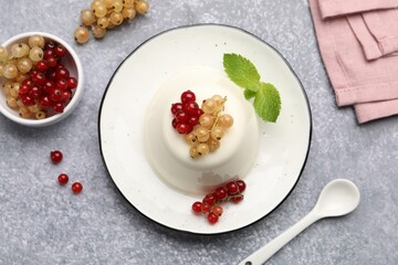 Tasty panna cotta with currants and mint on light grey table, flat lay